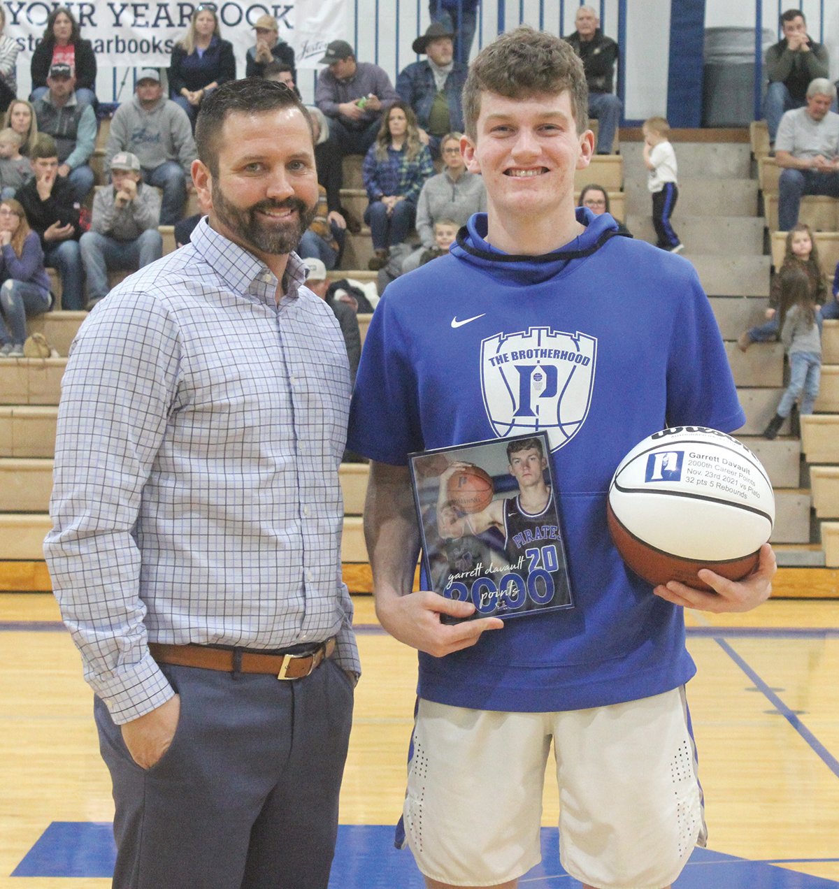 Garrett Davault, right after receiving a basketball and a photo from head coach Shane Chadwell to recognize him for scoring 2,000 career points.